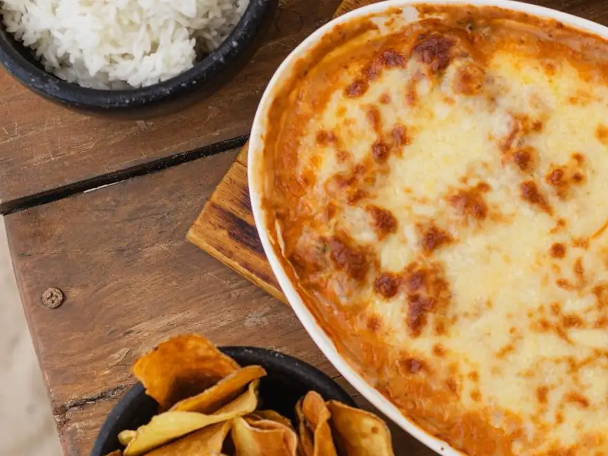 Gratinado do Bistrô: peixe empanado coberto de queijo gratinado, com arroz e chips